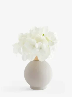 Arrangement met kunsthortensia in kleine grijze glazen vaas