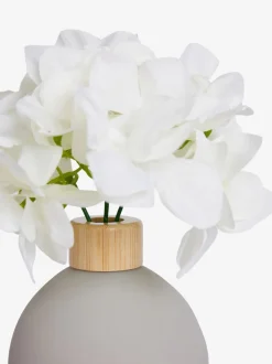 Arrangement met kunsthortensia in kleine grijze glazen vaas