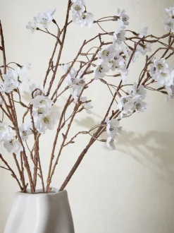 Kunstbloesemstelenarrangement in witte keramische vaas
