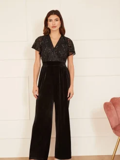 Zwart - Yumi jumpsuit met engelmouwen, van fluweel en versierd met lovertjes