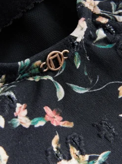 Zwart met broderie en fijne print - Badpak met vormgevende zijrimpeling en buikcorrectie