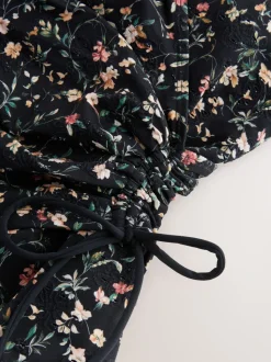 Zwart met broderie en fijne print - Badpak met vormgevende zijrimpeling en buikcorrectie